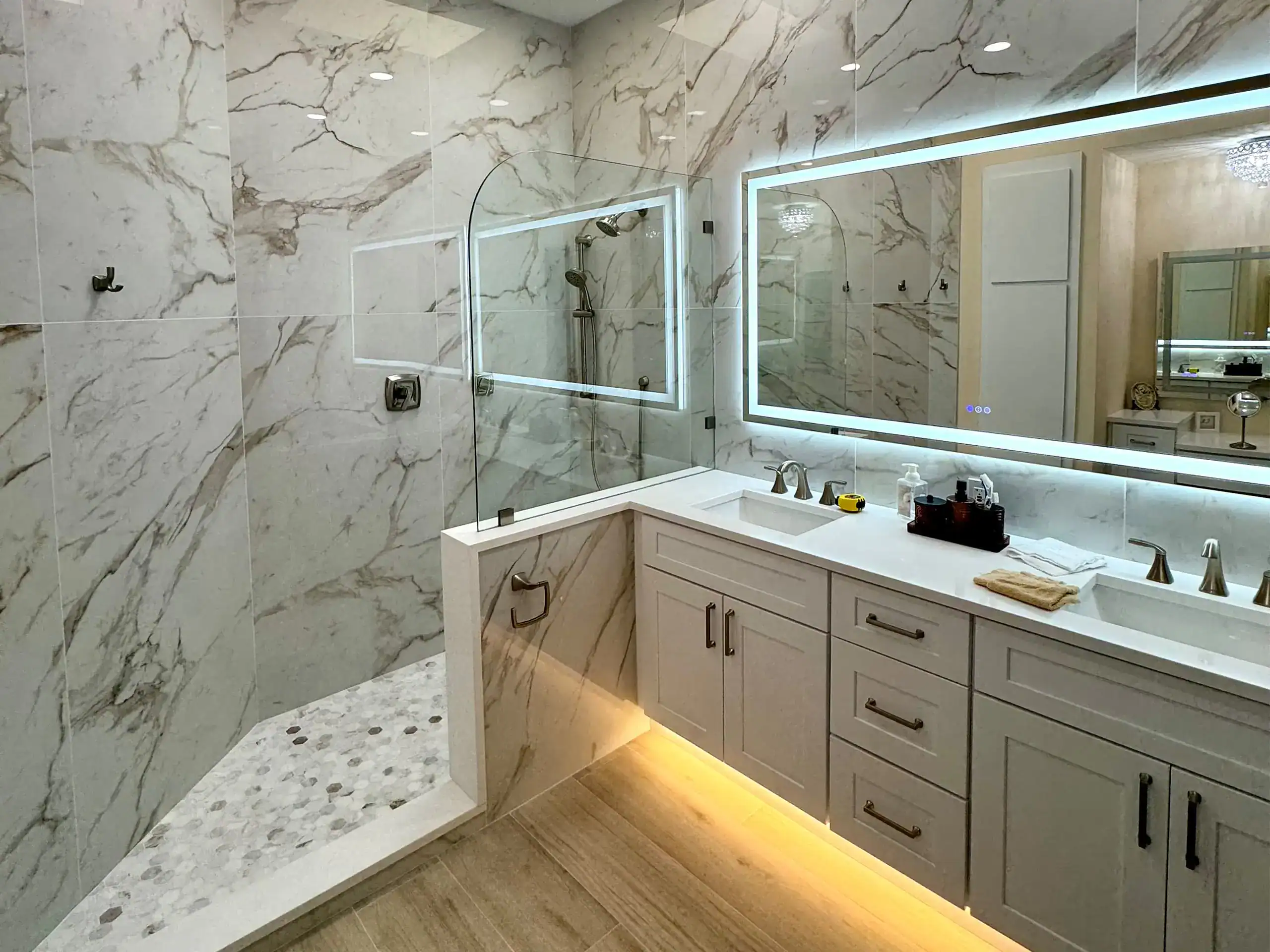 Frameless glass shower panel in a marble bathroom installed by All Glass 4 U